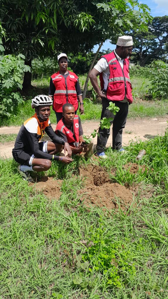 Volunteers and cycling club members planting trees during a community drive